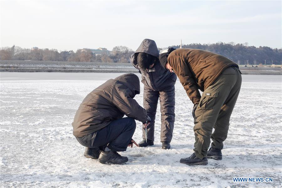 Citizens ice fish on the frozen Taedong River in Pyongyang, capital of the Democratic People's Republic of Korea (DPRK), on Jan. 22, 2016. 