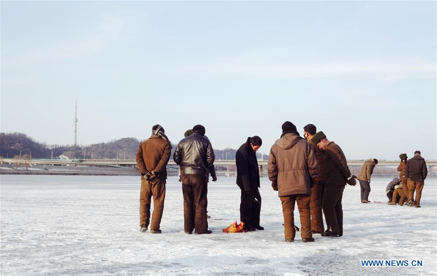 Citizens ice fish on the frozen Taedong River in Pyongyang, capital of the Democratic People's Republic of Korea (DPRK), on Jan. 22, 2016. 