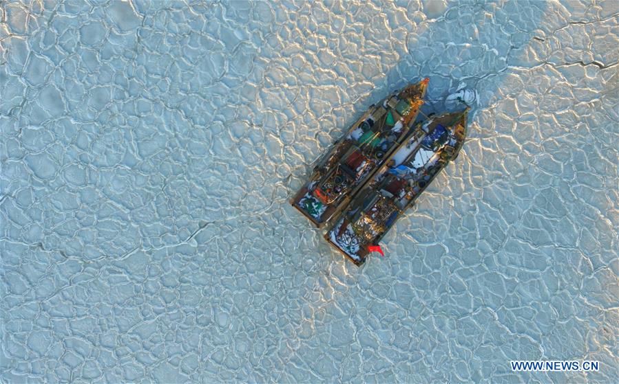 YANTAI, Jan. 26, 2016 (Xinhua) -- Photo taken with a drone on Jan. 26, 2016 shows fishing boats trapped in sea ice in a port at Xikou Village in Yantai City, east China's Shandong Province. Under the influence of a strong cold wave, sea ice appeared around the Yantai sea area and affected the maritime transportation. (Xinhua/Chu Yang) 