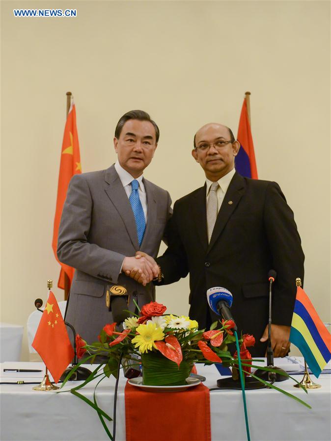 Visiting Chinese Foreign Minister Wang Yi (L) shakes hands with Etienne Sinatambou, Minister of Foreign Affairs, Regional Integration and International Trade of Mauritius during a press conference in Flic en Flac, Mauritius, on Feb. 1, 2016. 