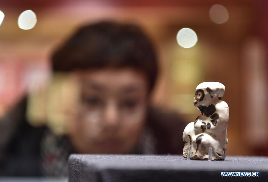 A visitor views a monkey-shaped figurine at the Capital Museum in Beijing, capital of China, Feb. 1, 2016.