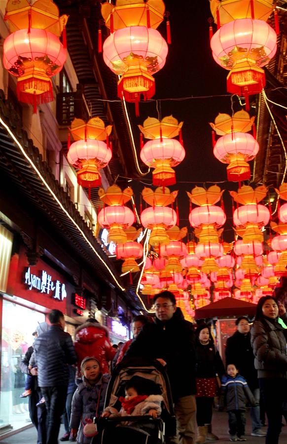 People walk under lanterns at Yuyuan Garden in Shanghai, east China, Feb. 12, 2016. Lanterns are lit up at Yuyuan Garden for the annual Spring Festival. 