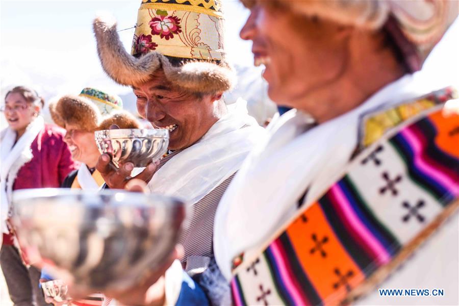 People drink during the ceremony of a game called 'hit the horn', in celebration of Losar, the Tibetan New Year, in Dagze County, Lhasa, capital of southwest China's Tibet Autonomous Region, Feb. 12, 2016. 