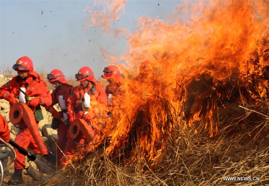 Soldiers take part in a fire drill at a forest zone in Xixiang Township, Xichang City of southwest China's Sichuan Province, Feb. 16, 2016. 