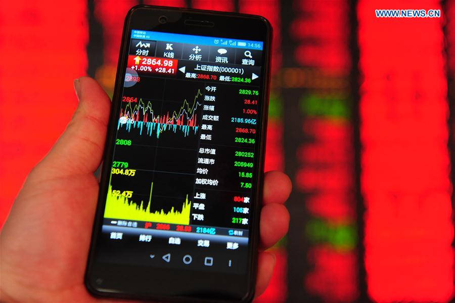  An investor checks stock prices on a smartphone at a securities company in Fuyang, east China's Anhui Province, Feb. 17, 2016. 