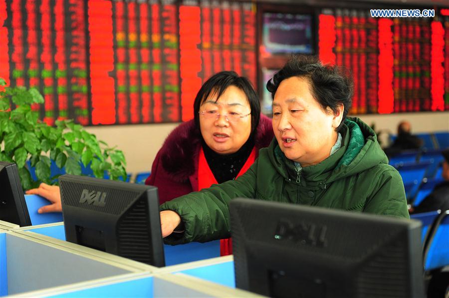 Investors watch a screen in a securities company in Fuyang, east China's Anhui Province, Feb. 17, 2016.