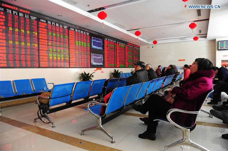 Investors watch a screen at a securities company in Fuyang, east China's Anhui Province, Feb. 17, 2016. 