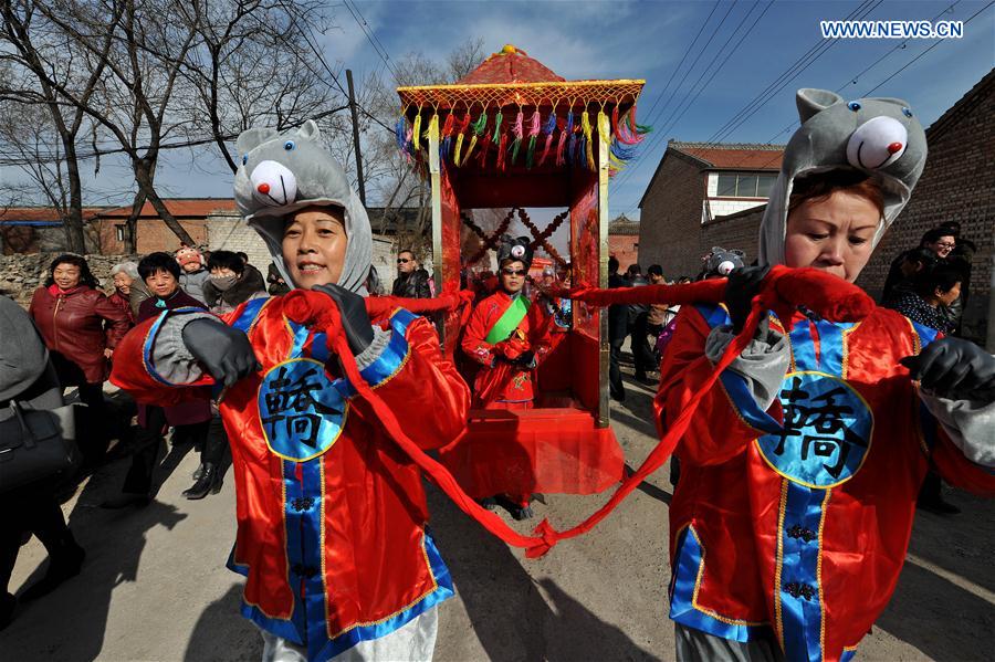 Folk artists wearing mouse costumes carry a bridal sedan during a 'mouse marriage' shehuo show in Jiacun Village of Lucheng, north China's Shanxi Province, Feb. 17, 2016.