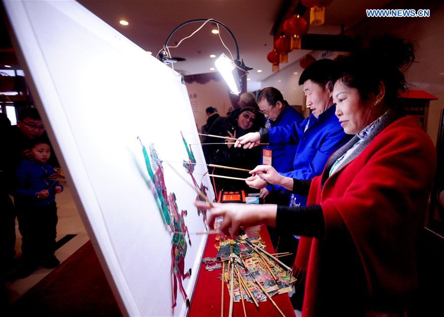 Folk artist Lin Shimin (1st R) performs Gaizhou shadow play during an intangible cultural heritage show at Liaoning Grand Theater in Shenyang, northeast China's Liaoning Province, Feb. 18, 2016. 