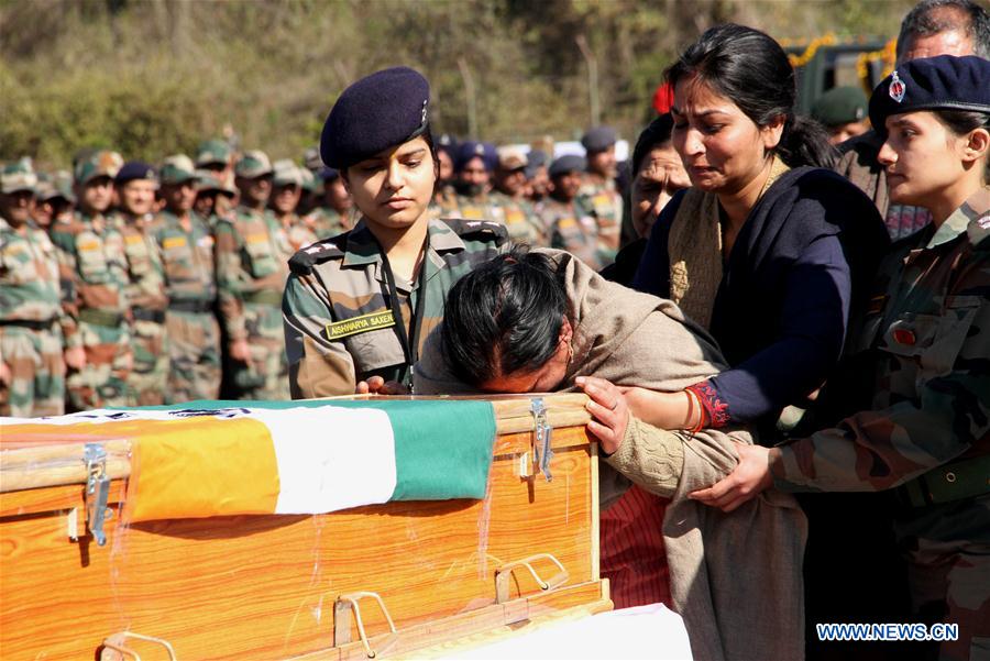 Mother of Indian Army Captain Tushar Mahajan cries next to the coffin of his son at Udhampur's military station, Indian-controlled Kashmir, on Feb. 22, 2016.