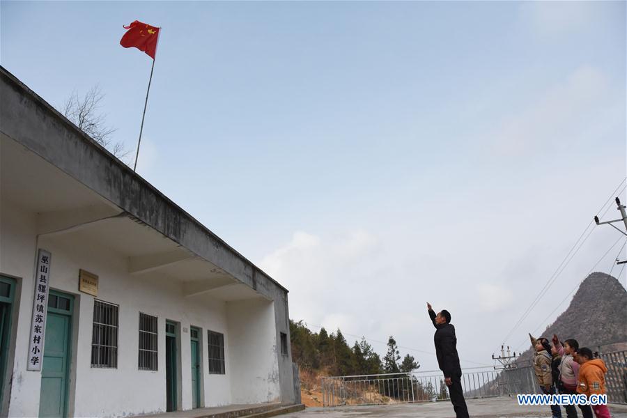 Primary school teacher Tao Chaolei, 52, and his four students, including one in grade three and three pre-school kids, salute the national flag at the start of the new term at Sujiacun Village of Wushan County in southwest China's Chongqing, Feb. 24, 2016.