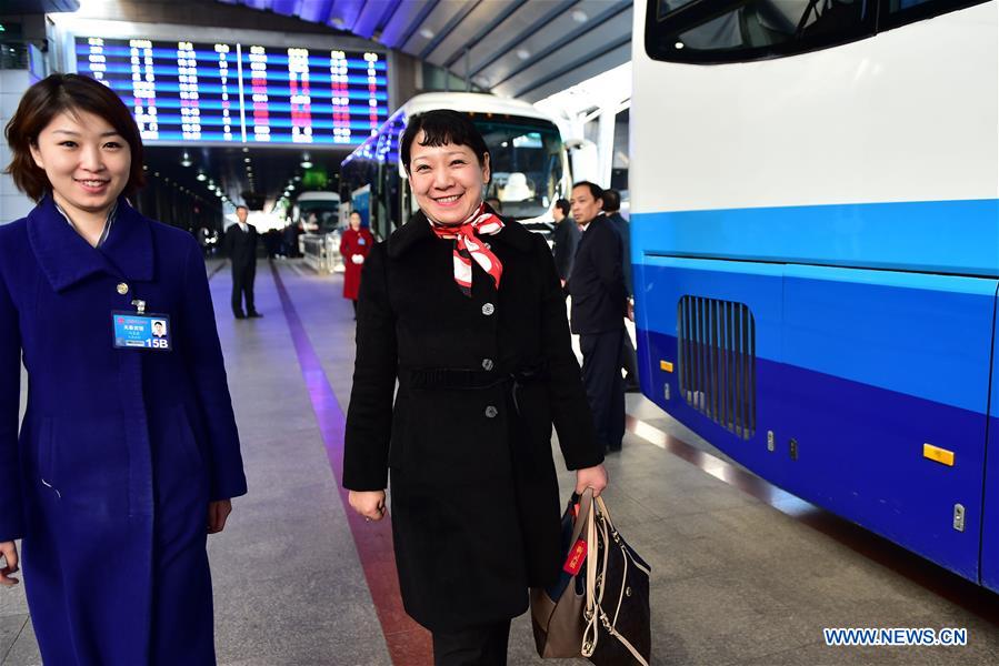 Jin Lingzhan (R), a deputy to the 12th National People's Congress (NPC) from north China's Hebei Province, walks to a shuttle bus after she arrives at Beijing West Railway Station in Beijing, capital of China, March 2, 2016. The fourth annual session of the 12th NPC will open on March 5. [Photo: Xinhua]