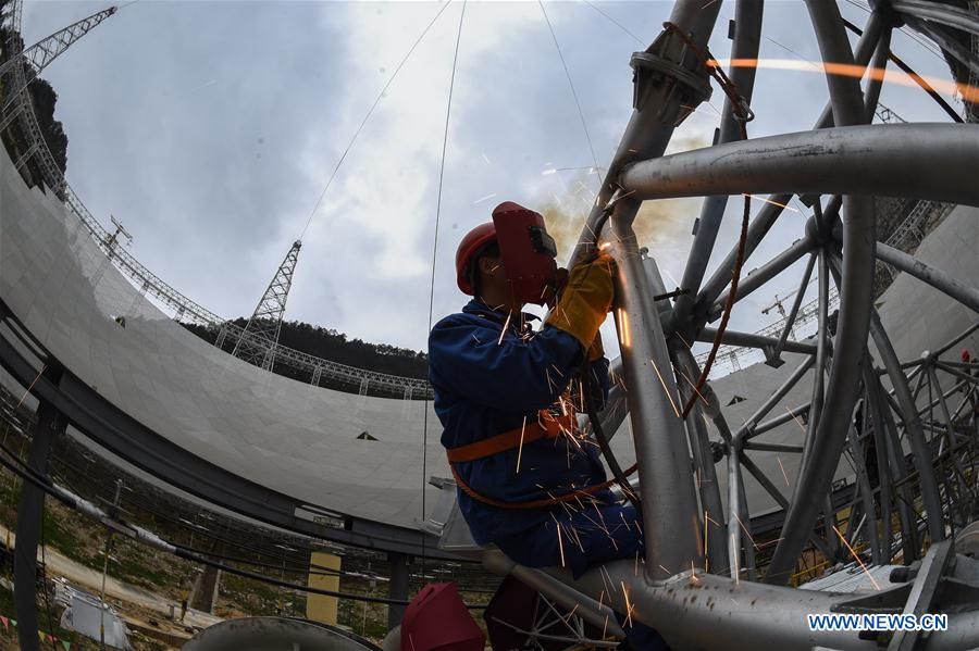 A worker assembles the single-aperture spherical telescope 'FAST' in Pingtang County, southwest China's Guizhou Province, March 9, 2016.