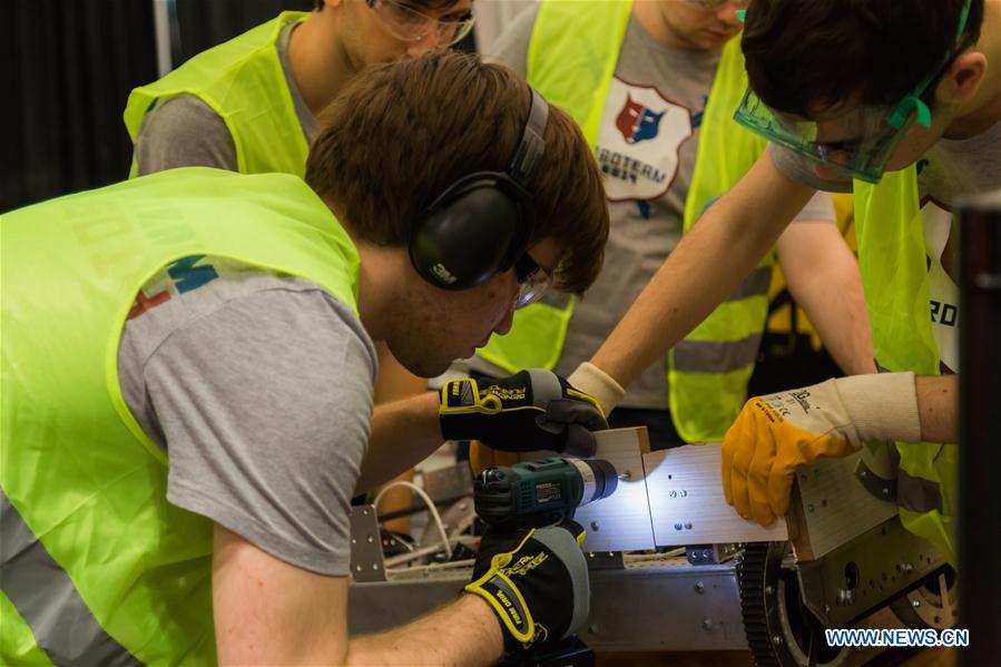 Team members of 'FLYBOTS' from Brooklyn's Paul Robeson High School work on their robot at the 2016 FIRST Robotics Competition New York Regional in Jacob Javits Convention Center in New York City, the United States, March 11, 2016.