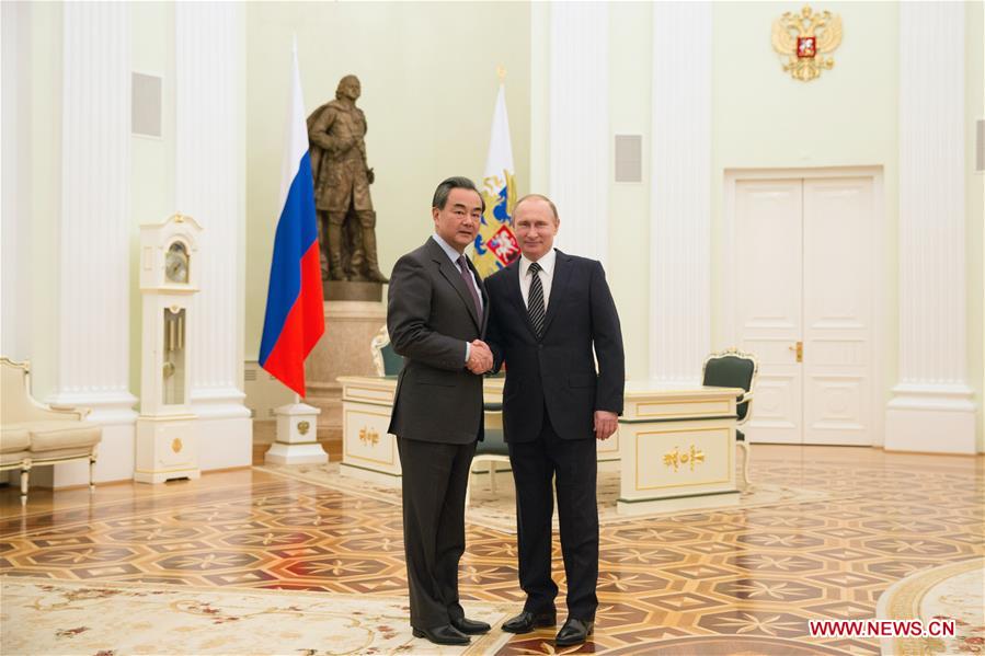 Russian President Vladimir Putin (R) shakes hands with visiting Chinese Foreign Minister Wang Yi during their meeting in Moscow, capital of Russia, on March 11, 2016. 