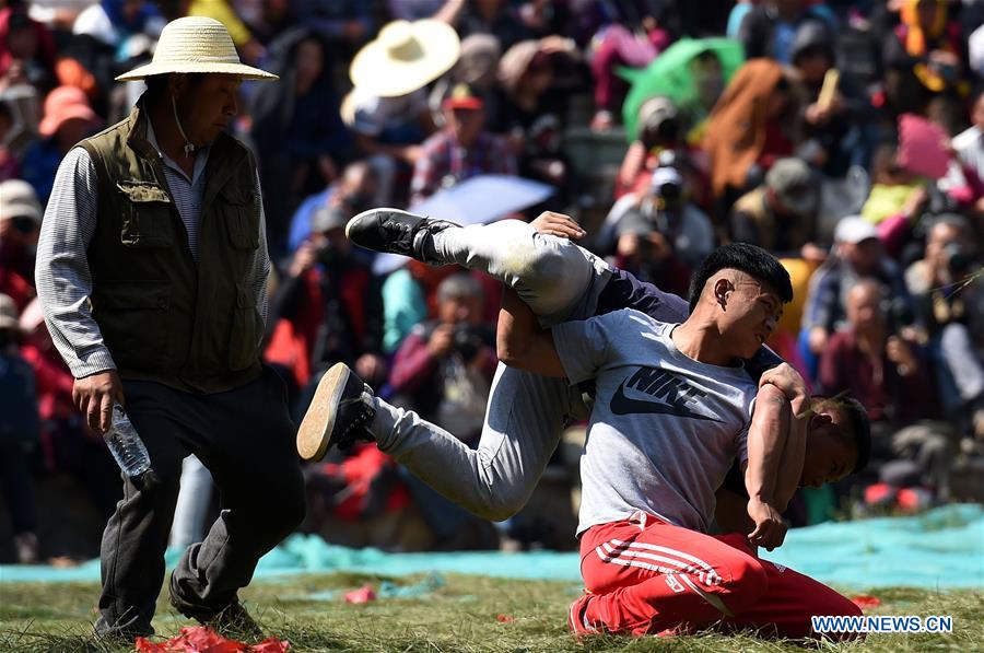 People of Yi ethnic group perform wrestling during the annual fire worshipping festival, which falls on the third day of the second month in the Chinese lunar calendar, in Hongwan Village of Xiyi Township in Mile City, southwest China's Yunnan Province, March 11, 2016.