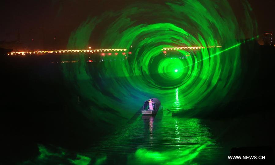 An actor paddles a boat on water during an on-water performance reproducing the prosperity of capital city Kaifeng (historically known as Daliang, Bianliang, Bianjing, Dongjing) of Northern Song Dynasty (960-1127 AD) in Kaifeng, Central China's Henan Province, March 11, 2016