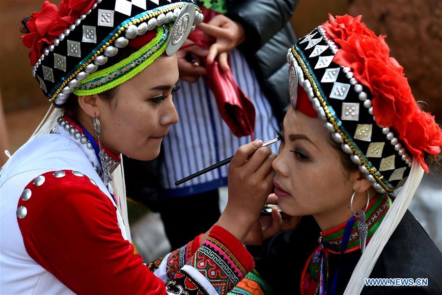 People of Yi ethnic group make up to perform 'Axi Dance in the Bright Moonlight,' during the annual fire worshipping festival, which falls on the third day of the second month in the Chinese lunar calendar, in Hongwan Village of Xiyi Township in Mile City, southwest China's Yunnan Province, March 11, 2016.