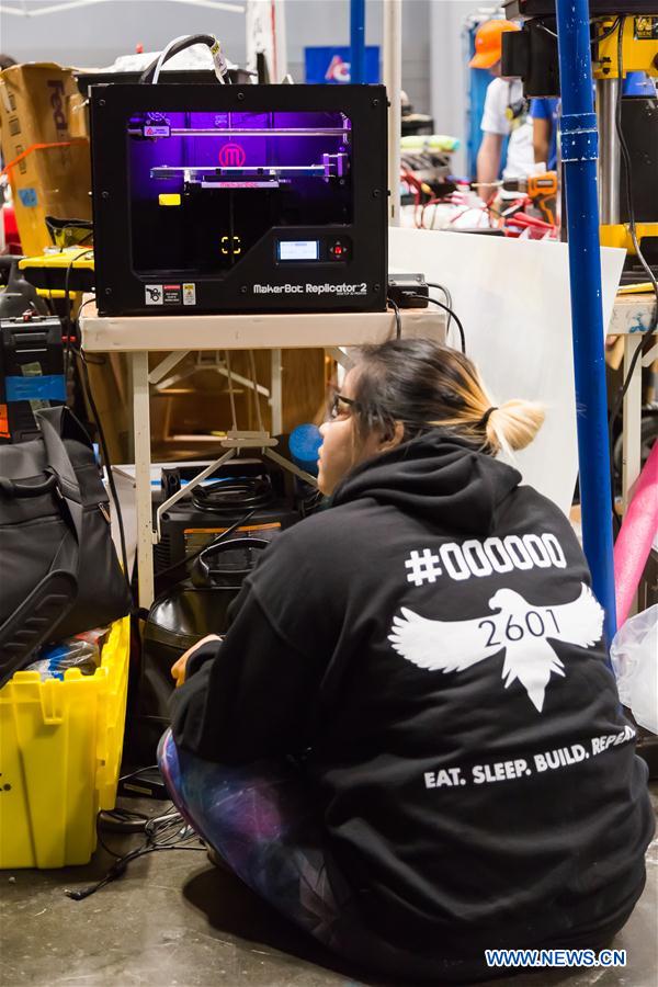 Team members of 'FLYBOTS' from Brooklyn's Paul Robeson High School work on their robot at the 2016 FIRST Robotics Competition New York Regional in Jacob Javits Convention Center in New York City, the United States, March 11, 2016.