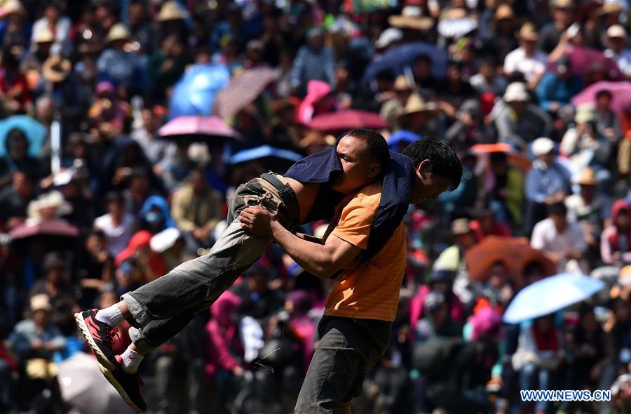 People of Yi ethnic group perform wrestling during during the annual fire worshipping festival, which falls on the third day of the second month in the Chinese lunar calendar, in Hongwan Village of Xiyi Township in Mile City, southwest China's Yunnan Province, March 11, 2016.