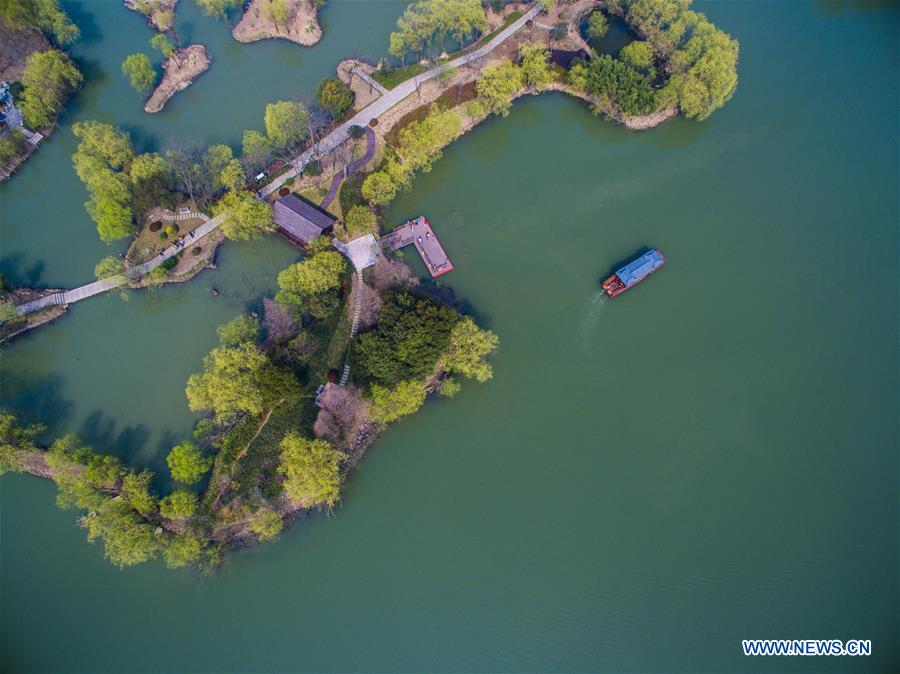 A sightseeing boat sails on water at a wetland by the Taihu Lake in Changxing County, est China's Zhejiang Province, March 16, 2016. 