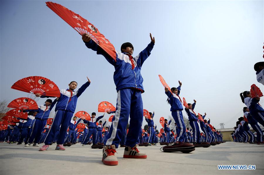 Pupils of Foyelai Primary School exercise with Taiji fans in Xinglong County of Chengde City, north China's Hebei Province, March 16, 2016. 