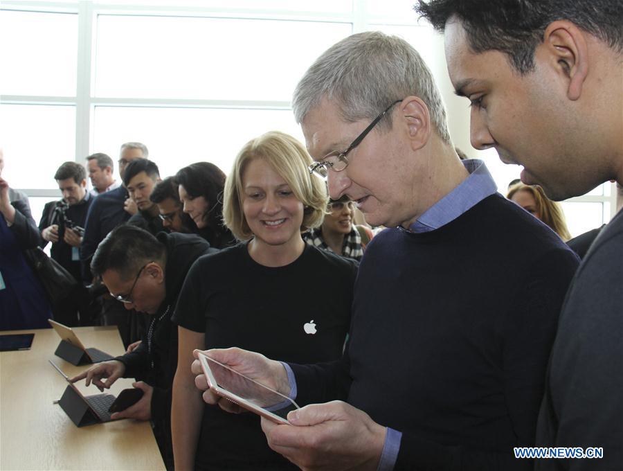 Visitors take photos of the new iPhones, named iPhone SE, during an event to announce new products at Apple's headquarters in Cupertino, California, the United States, March 21, 2016. 