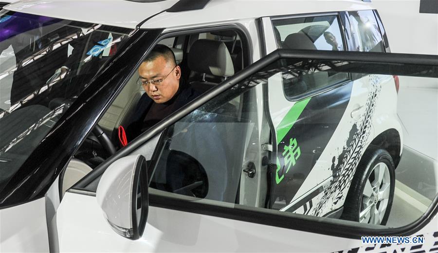 A man experiences a car of Skoda during the 11th Harbin spring auto show in Harbin, capital of northeast China's Heilongjiang Province, March 22, 2016.