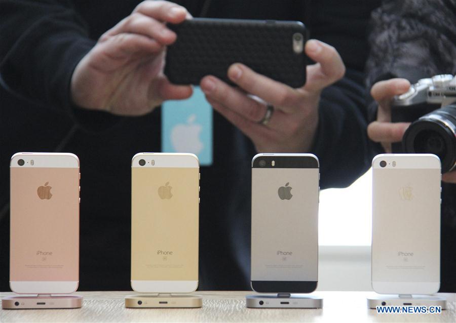 Visitors take photos of the new iPhones, named iPhone SE, during an event to announce new products at Apple's headquarters in Cupertino, California, the United States, March 21, 2016. 