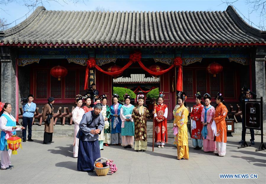 Performers dressed in traditional costumes welcome guests at Rong Mansion in Zhengding County of Shijiazhuang City, north China's Hebei Province, March 29, 2016.