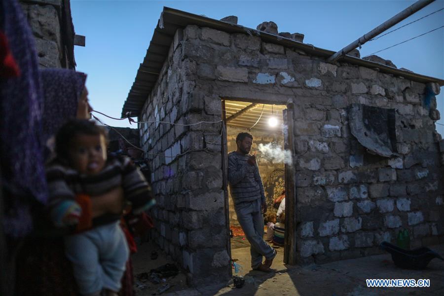 Palestinian Majid Abu Nimer smokes inside his makeshift house in the southern Gaza Strip city of Khan Younis, on April 6, 2016. 