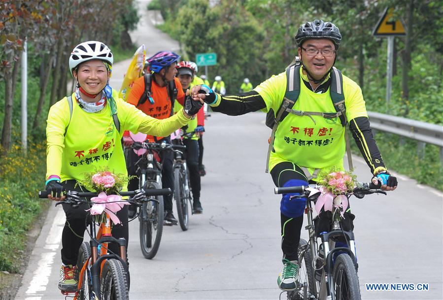 Bridegroom Zeng Di (R) and bride Wang Lixia ride during their wedding in Chengdu, capital of southwest China's Sichuan Province, April 9, 2016.