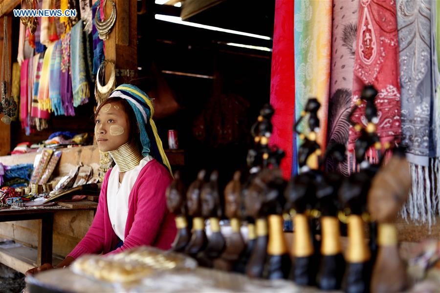 A Padaung woman with brass rings around her neck sits at a gift shop in Panpet Village, Demoso Township, Kayah State, Myanmar, April 11, 2016. 