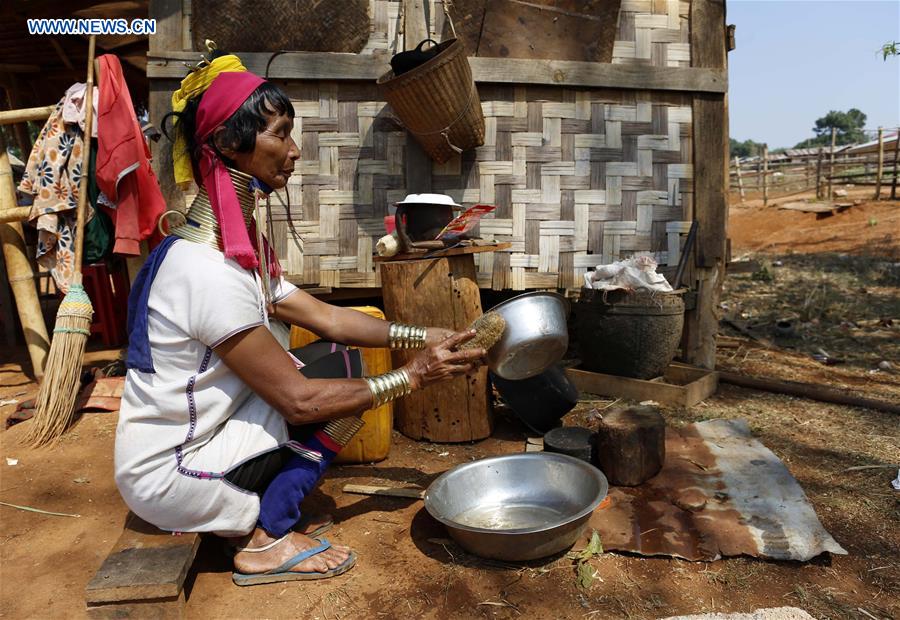 A Padaung woman with brass rings around her neck washes plates in Panpet Village, Demoso Township, Kayah State, Myanmar, April 11, 2016. 