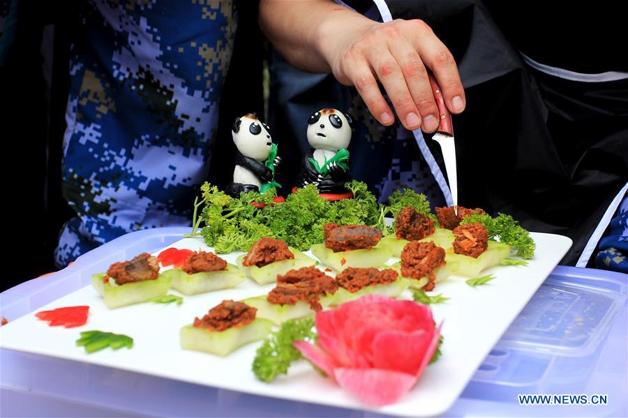 A chef from the Chinese Navy warship decorates the traditional cuisine of West Sumatra called Rendang at Padang, West Sumatra, Indonesia, April 13, 2016.