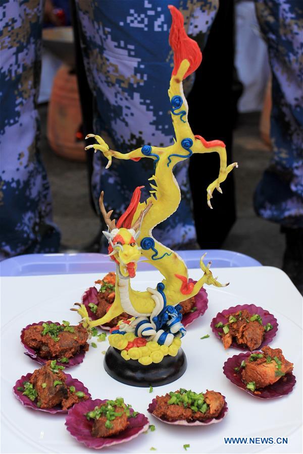 A chef from the Chinese Navy warship decorates the traditional cuisine of West Sumatra called Rendang at Padang, West Sumatra, Indonesia, April 13, 2016.