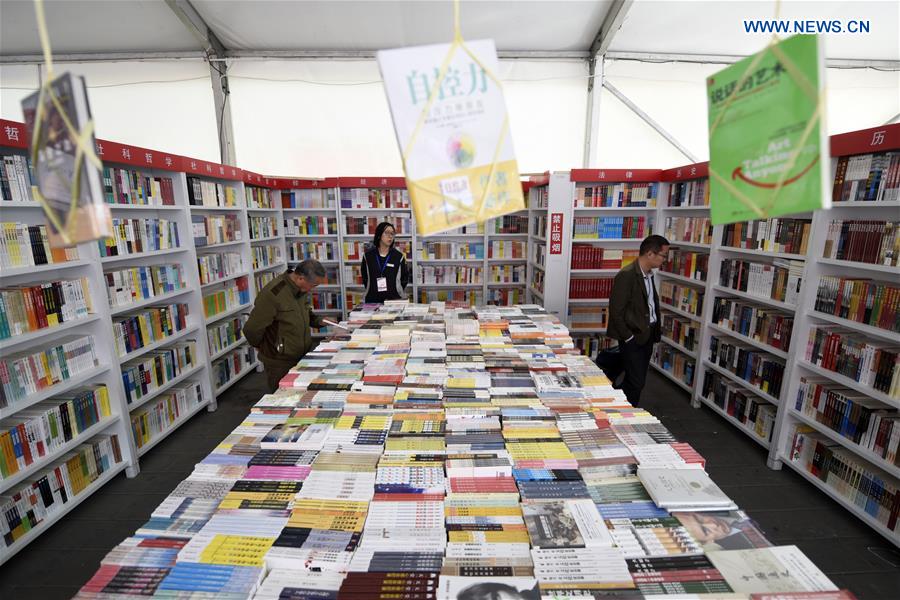 People select books at a book fair in Chaoyang Park in Beijing, capital of China, April 15, 2016. 