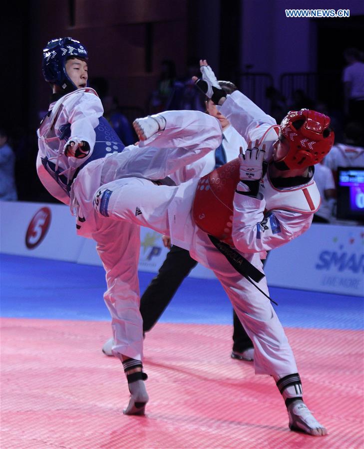 Kim Seok-Bae (L) of South Korea competes against Natsagdorj Achitkhuu of Mongolia in the men's -63kg category in the 22nd Asian Taekwondo Championships in Pasay City, the Philippines, April 19, 2016. 