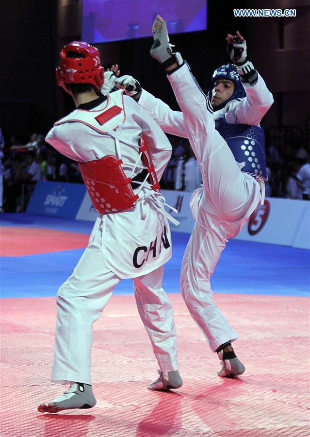 Zhao Shuai (L) of China competes against Saurav of India in the men's -63kg category in the 22nd Asian Taekwondo Championships in Pasay City, the Philippines, April 19, 2016. 