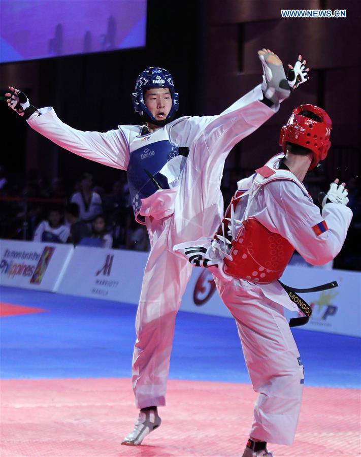 Kim Seok-Bae (L) of South Korea competes against Natsagdorj Achitkhuu of Mongolia in the men's -63kg category in the 22nd Asian Taekwondo Championships in Pasay City, the Philippines, April 19, 2016. 