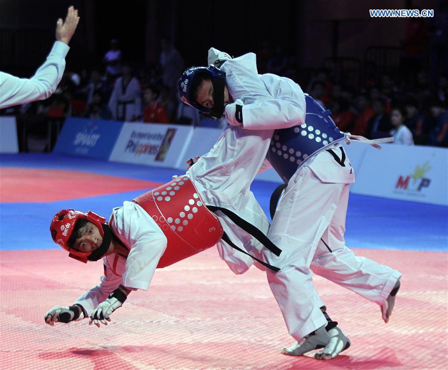 Arven Alcantara (L) of the Philippines competes against Huynh Hoai Nhan of Vietnam in the men's -63kg category in the 22nd Asian Taekwondo Championships in Pasay City, the Philippines, April 19, 2016.