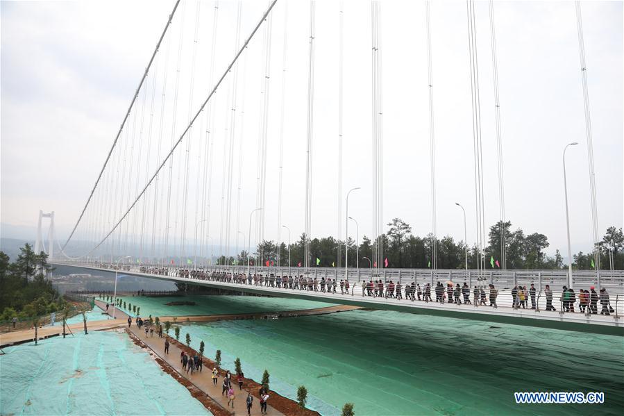 People walk on the newly-opened Longjiang grand bridge in southwest China's Yunnan Province, April 20, 2016. 