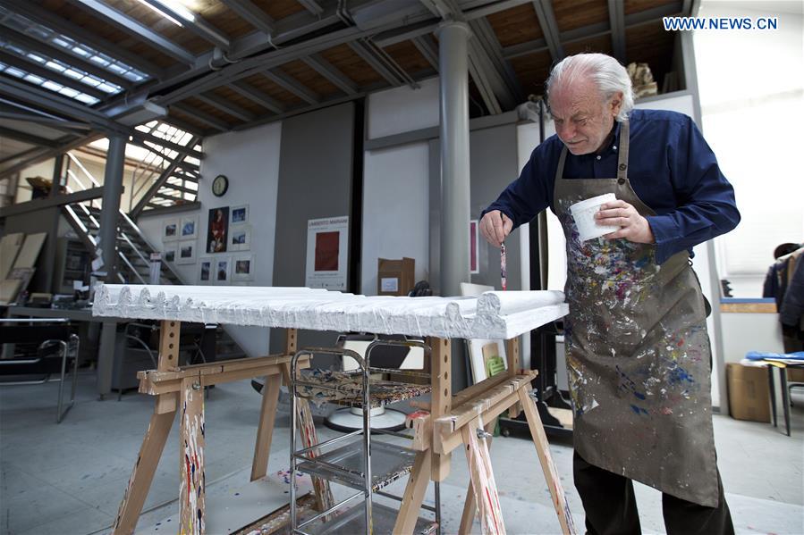 Mariani paints the fold made of lead sheet and fills up the pores at his studio in Milan, Italy, on April 13, 2016.