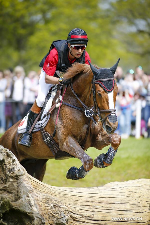 Chinese rider Alex Hua Tian with his horse 'Harbour Pilot C' jumps through the fence in Cross-Country Course at 2016 Badminton Horse Trials in Badminton, England on May 7, 2016.