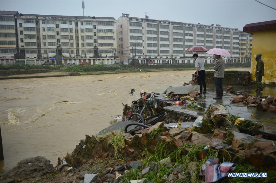 People check a transformer destroyed by floods in Lichuan County, east China's Jiangxi Province, May 9, 2016.