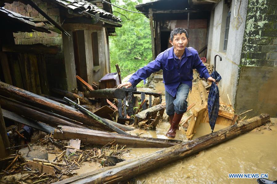 A man checks the condition of his house in Desheng Village of Lichuan County, east China's Jiangxi Province, May 9, 2016.