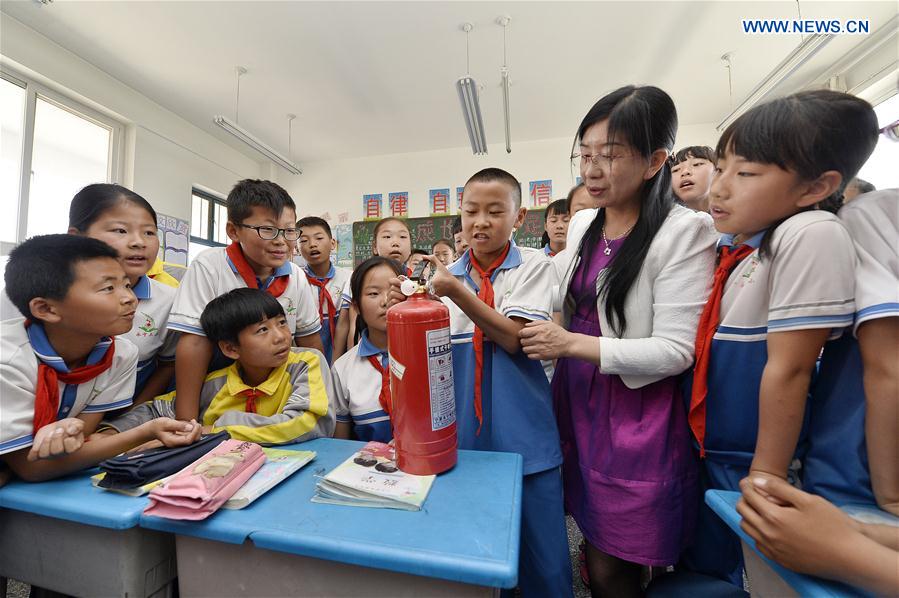 Students learn to use a fire extinguisher at the No. 3 primary school in Yongning County of northwest China's Ningxia Hui Autonomous Region, May 11, 2016. 