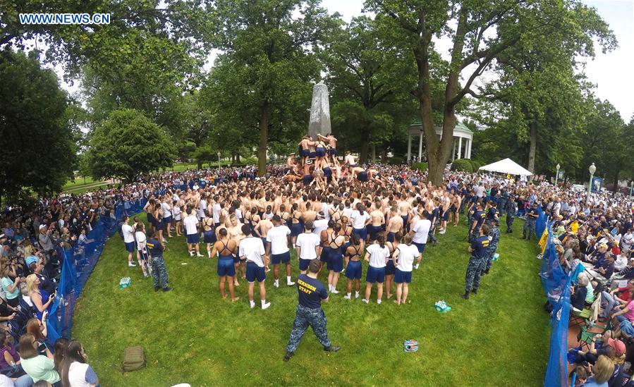 Plebes make a human wall to climb the Herndon Monument which is covered with vegetable shortening, at the U.S. Naval Academy (USNA) in Annapolis, Maryland, the United States, May 23, 2016.