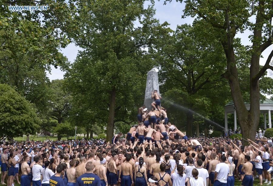 Plebes make a human wall to climb the Herndon Monument which is covered with vegetable shortening, at the U.S. Naval Academy (USNA) in Annapolis, Maryland, the United States, May 23, 2016.