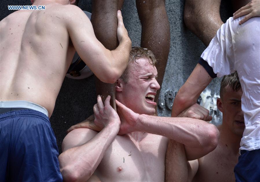 Plebes make a human wall to climb the Herndon Monument which is covered with vegetable shortening, at the U.S. Naval Academy (USNA) in Annapolis, Maryland, the United States, May 23, 2016. 